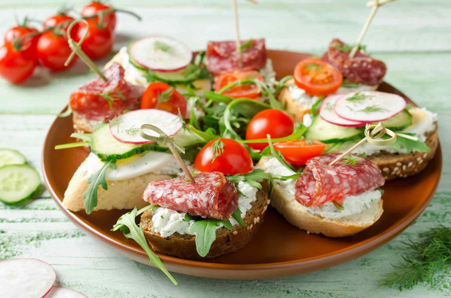 Plato con canapés de salchichon con queso crema y mermelada